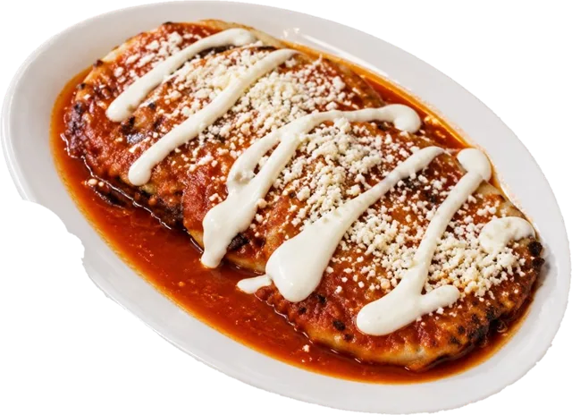 Pupusas ahogadas smothered in red salsa with crema and queso fresco